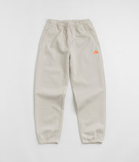 Nike ACG Tuff Fleece Lungs Pants in Light Orewood Brown and Hyper Crimson